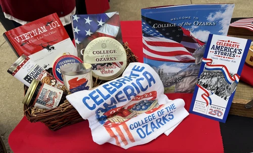 A thoughtfully arranged gift basket featuring handcrafted products made by students. The basket includes a freshly baked fruitcake, homemade fruit jelly, and a selection of patriotic-themed merchandise, showcasing the students' craftsmanship, creativity, and pride in their work.